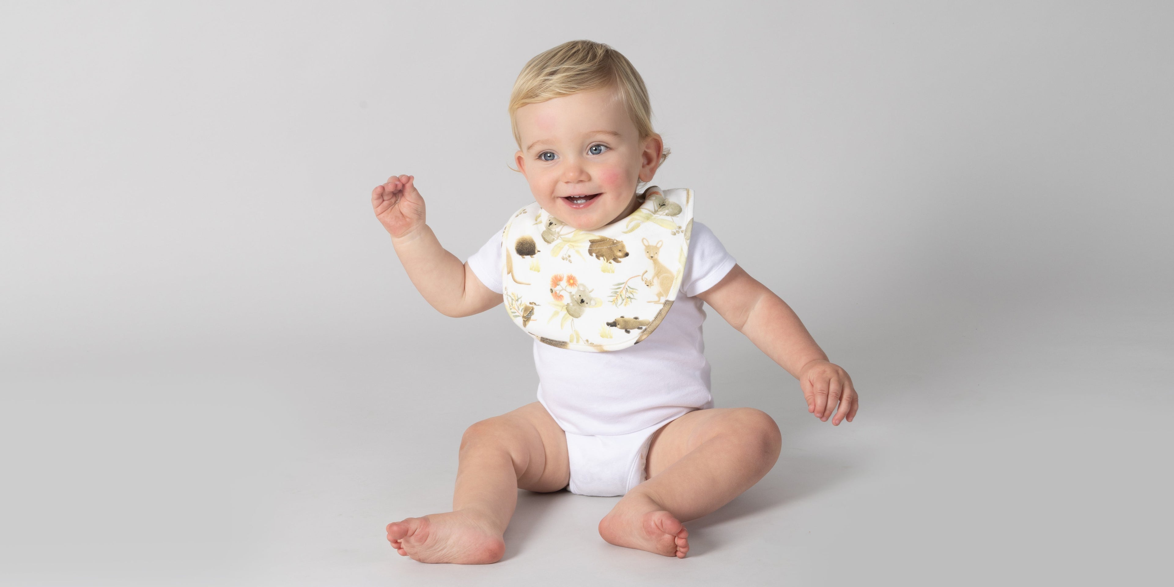baby wearing a bib in a highchair