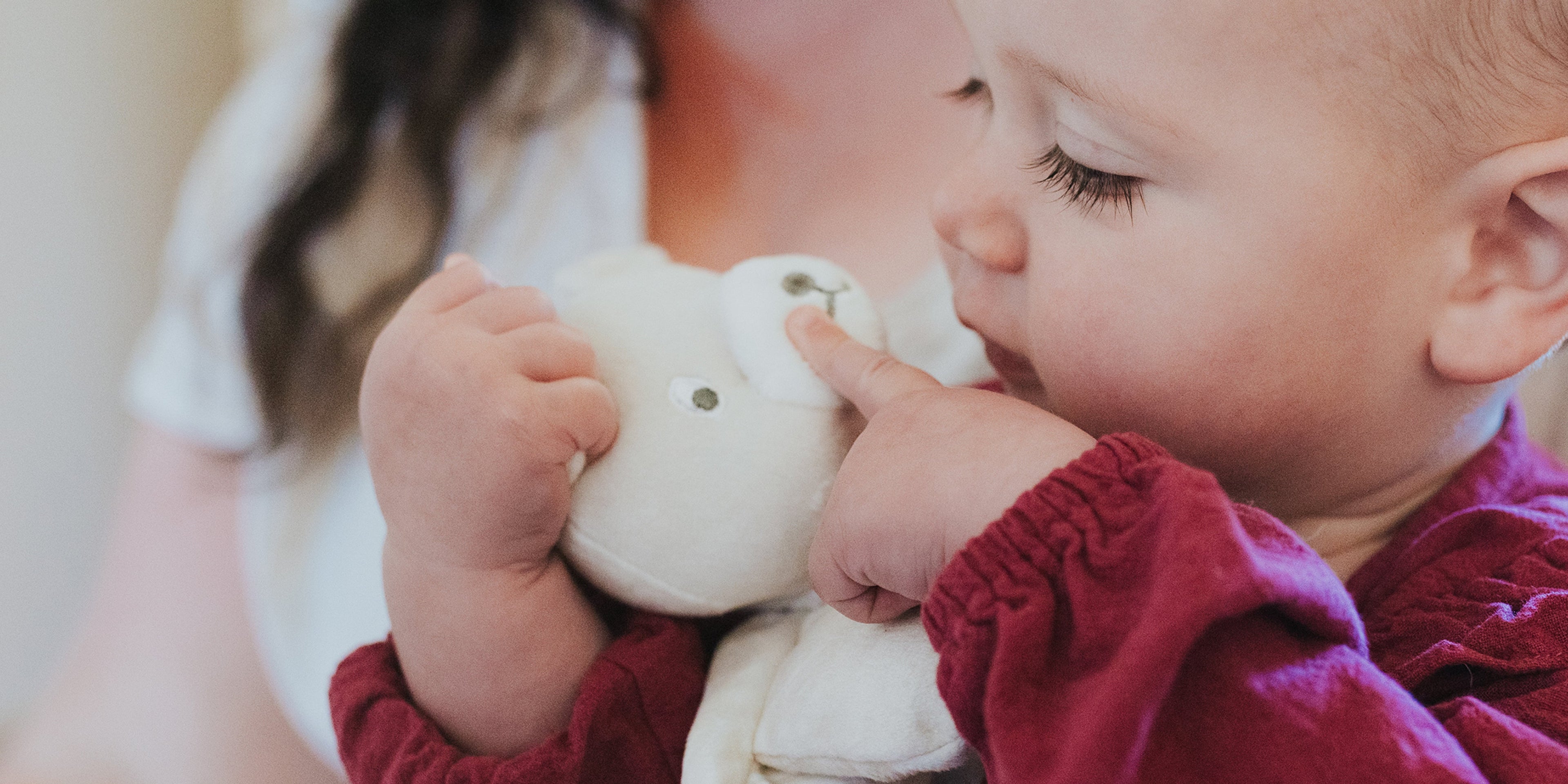 baby playing with a bear security blanket