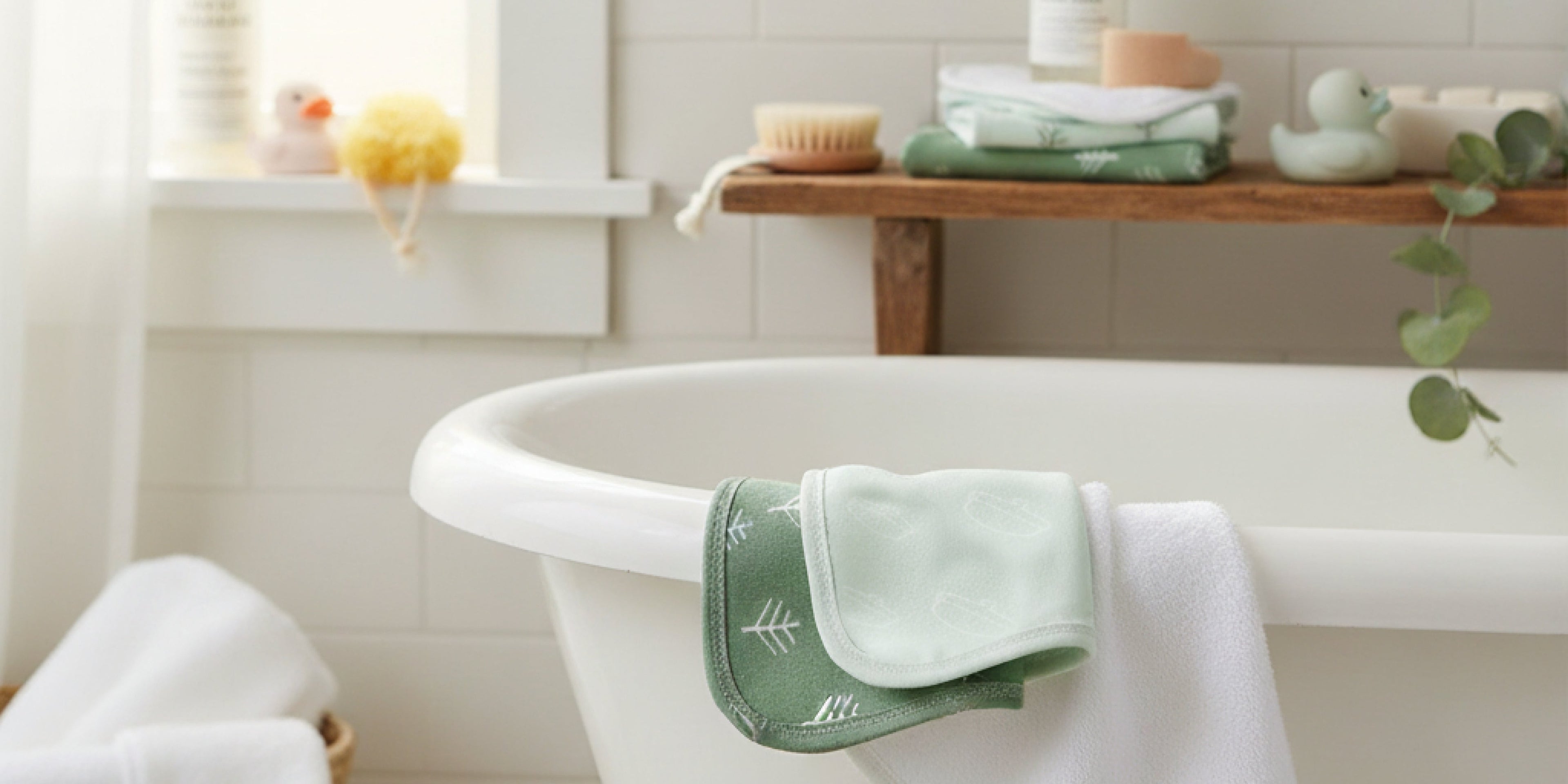 baby in bath with face washer wash cloth