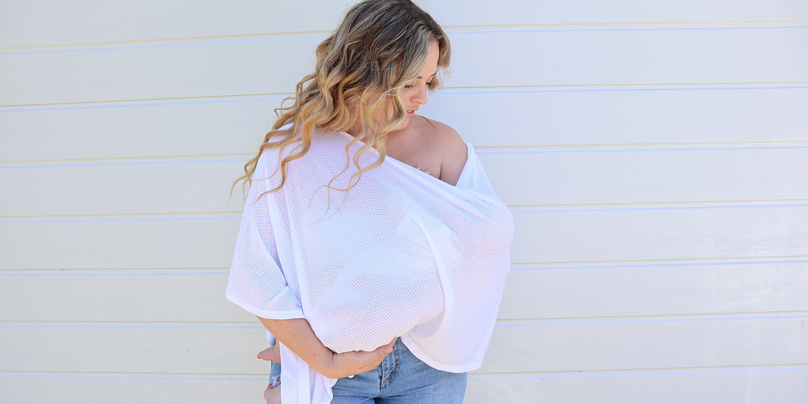 mother breastfeeding whilst wearing a nursing cover scarf