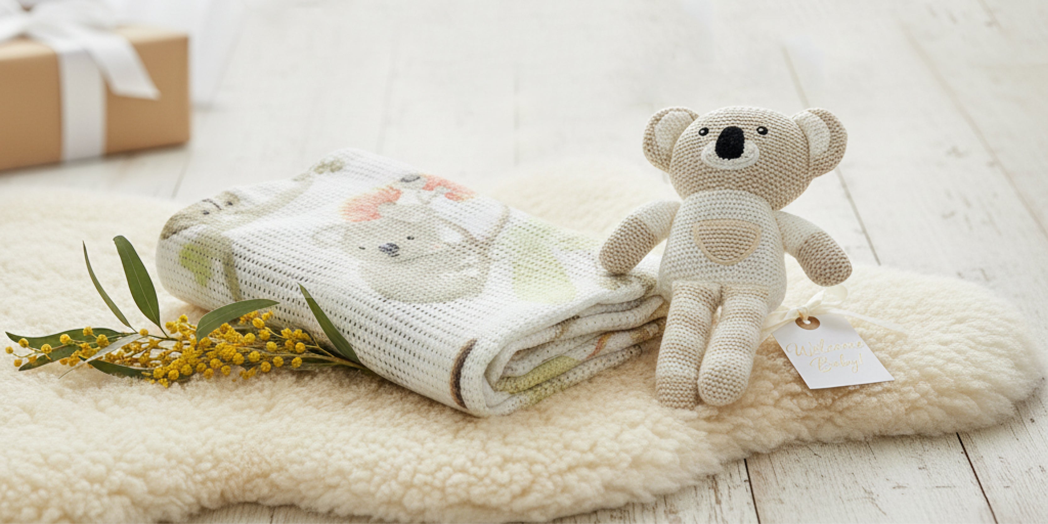 mother cradling a baby in a blanket with a bear toy and soother