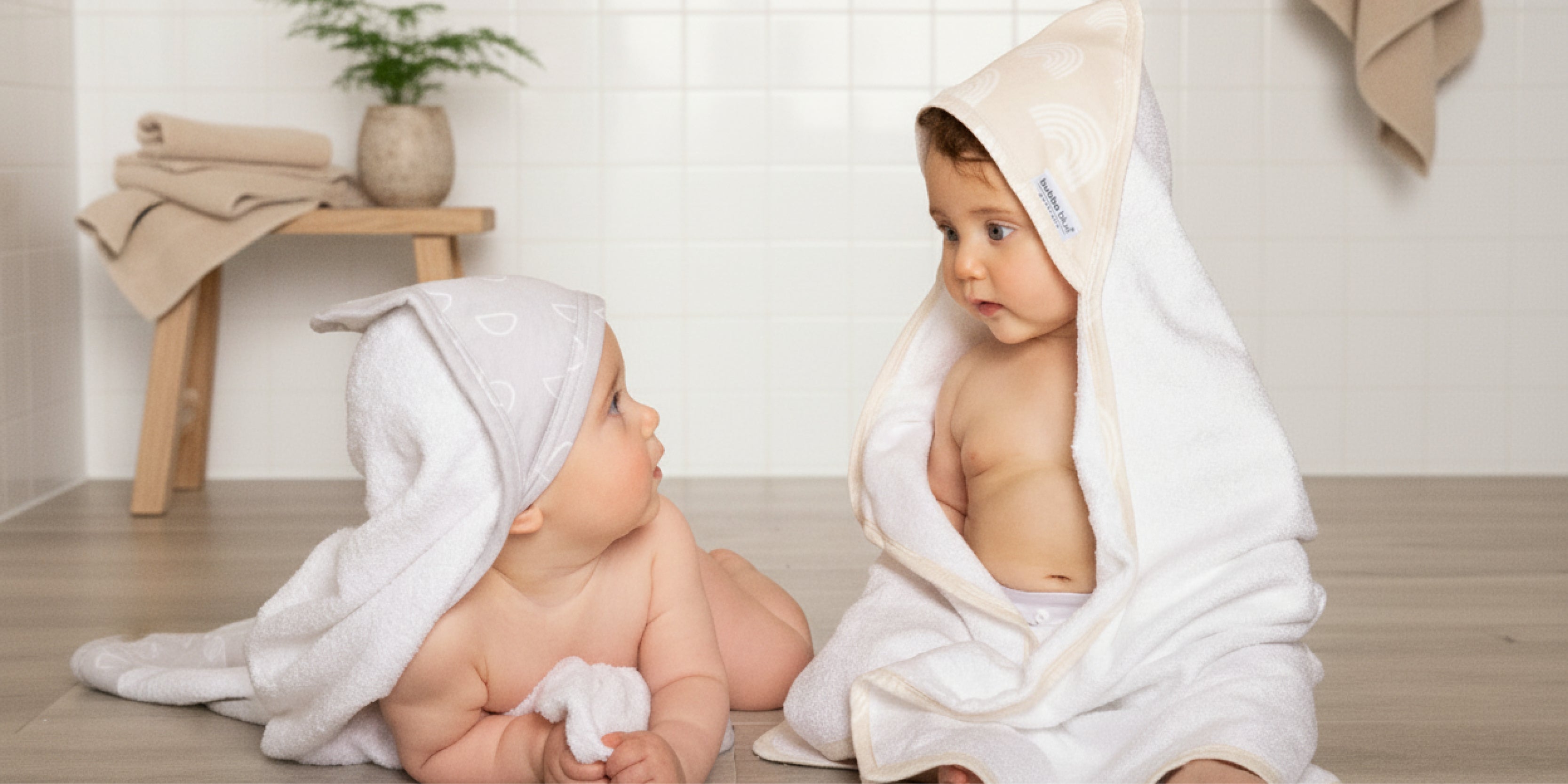 two cute babies wearing nordic inspired print hooded towels