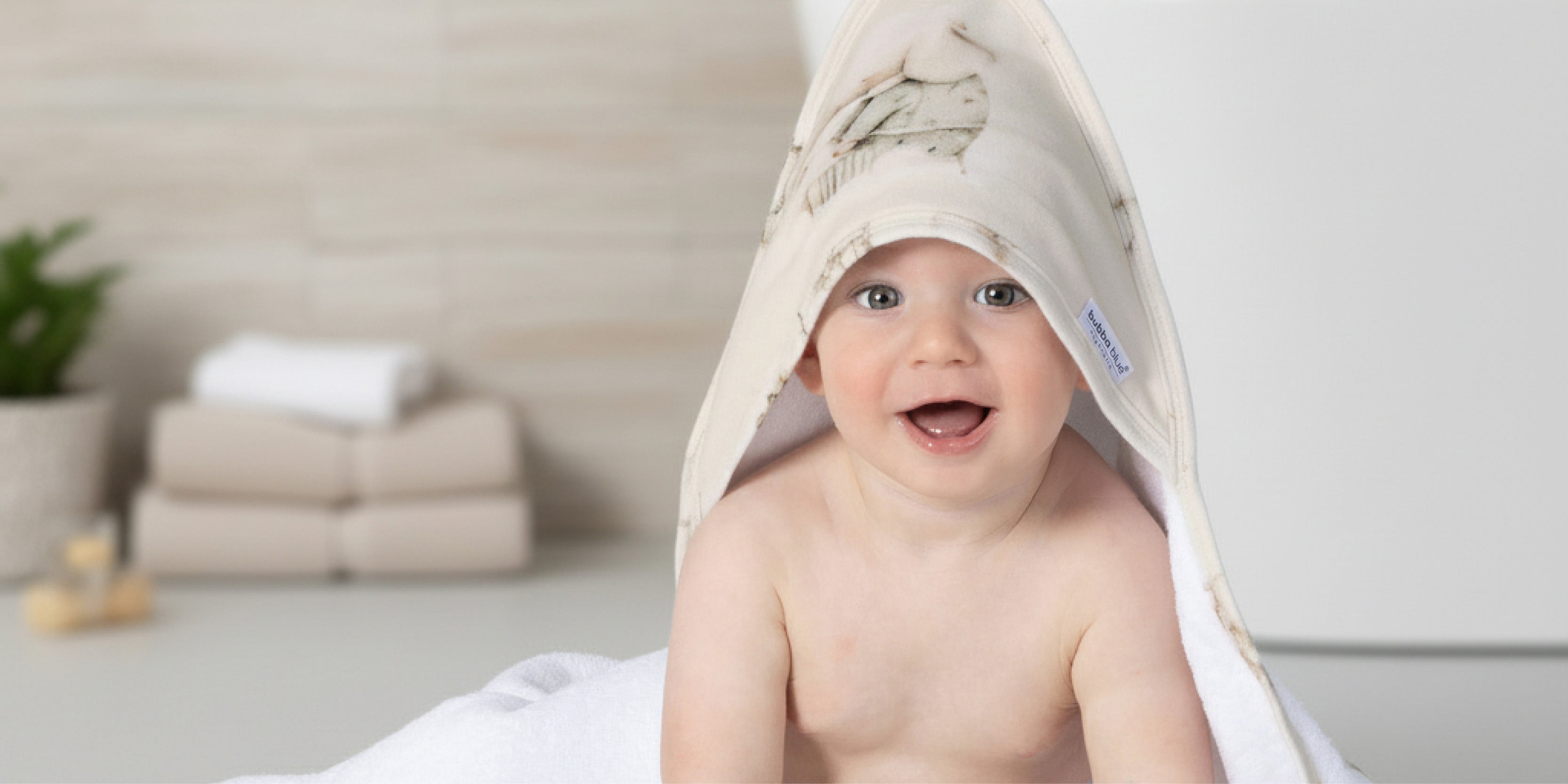 cute baby sitting in a basket of fleece blankets with nordic prints