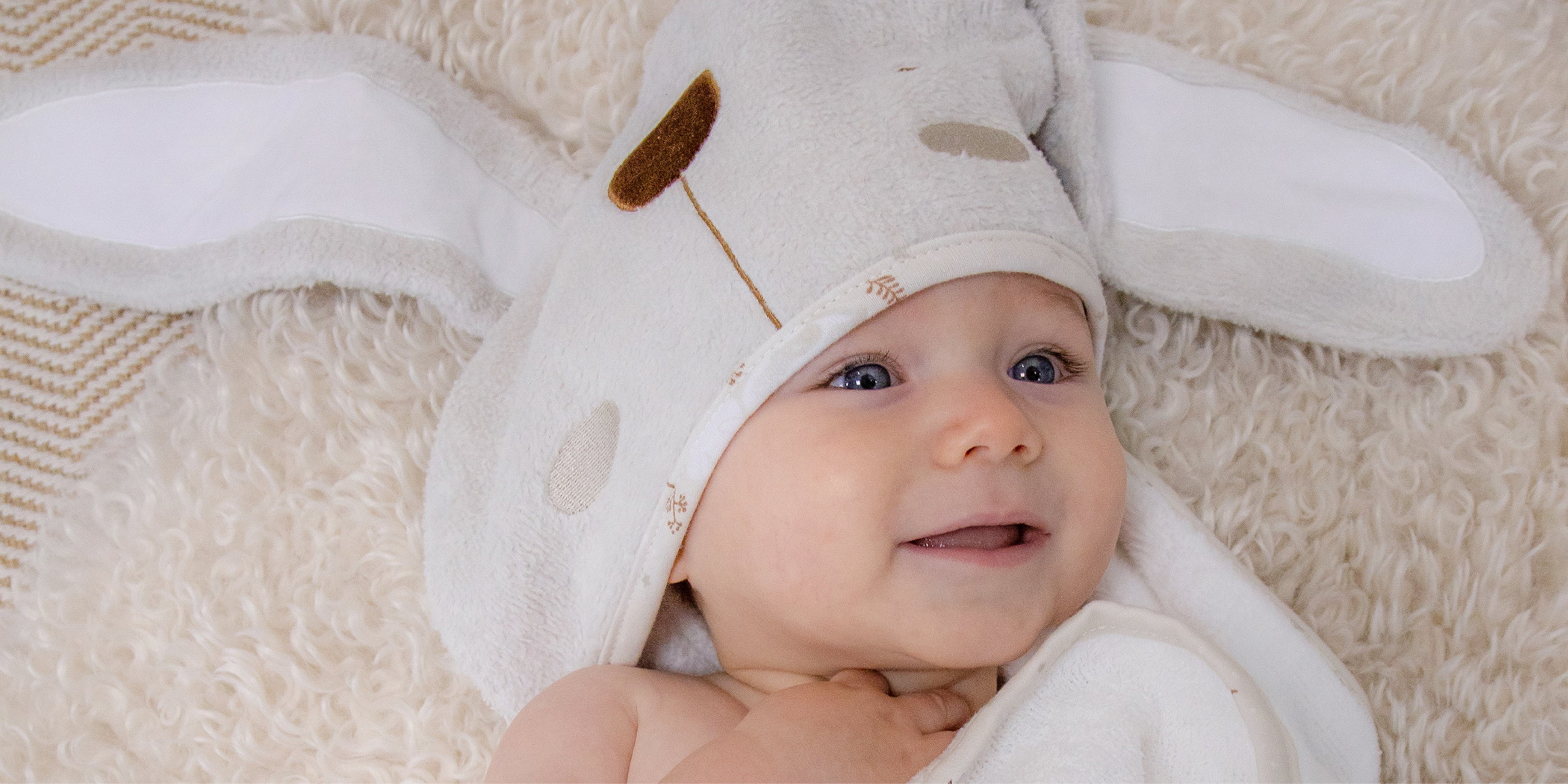 baby in cot with bunny themed sheet and comforter