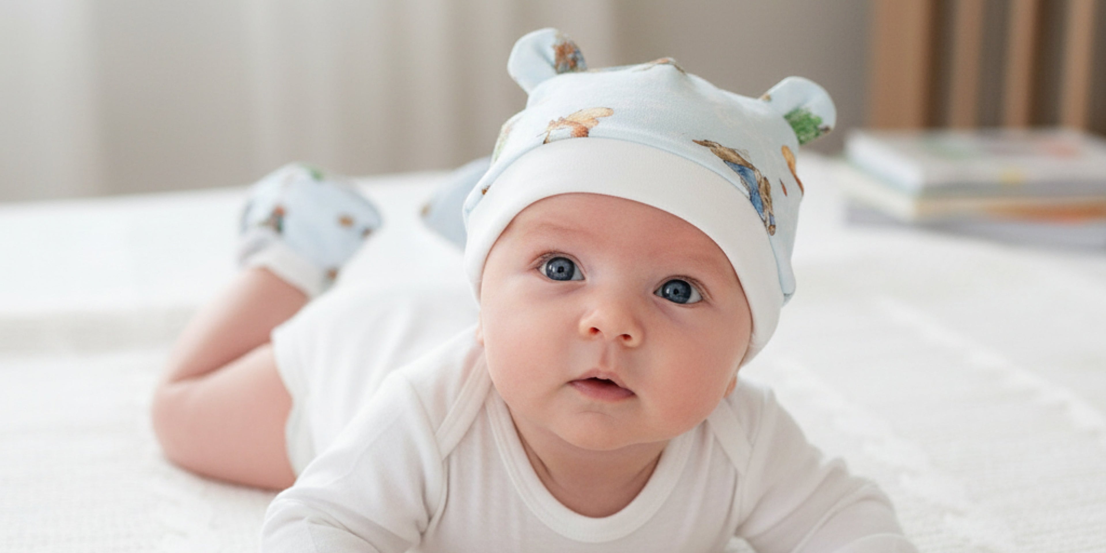 baby wearing a layette beanie and anti scratch mittens