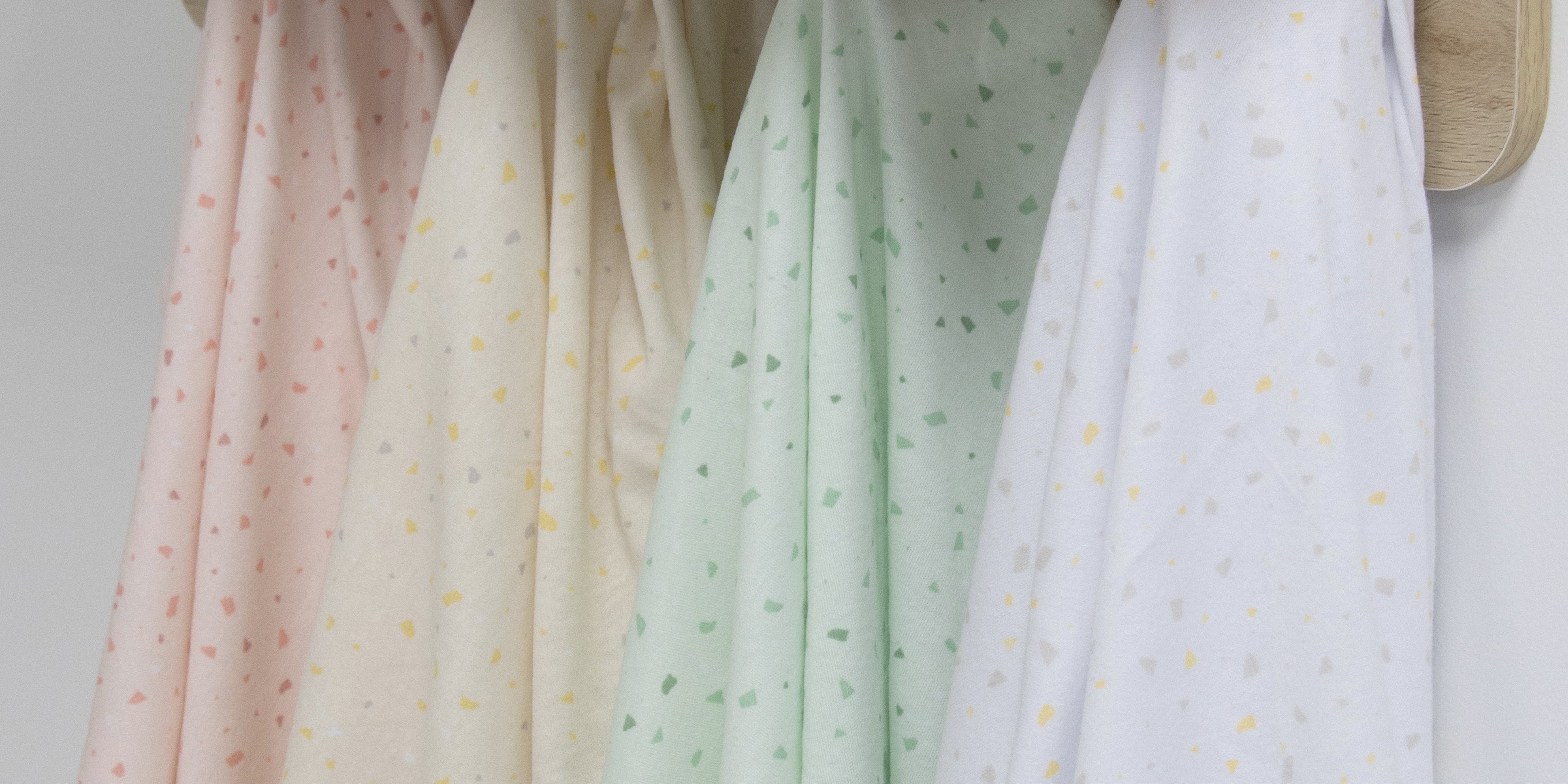 baby cot with white terrazzo print swaddle wrap