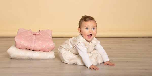 cute baby in sleeping bag with amazed look on its face